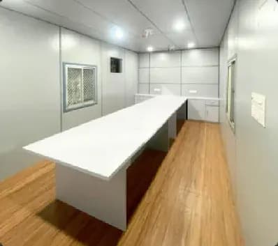 Cabin conference room interior with a long white table and wood floor