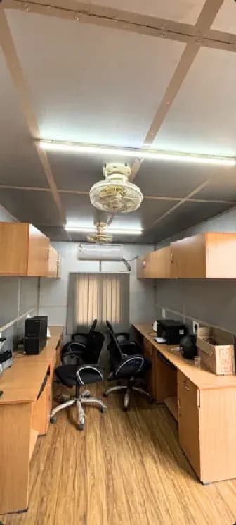 Multi-executive workstation cabin interior with desks and office chairs